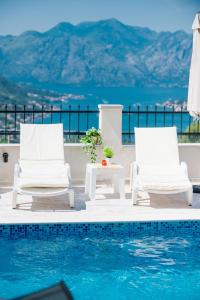 two chairs and a table next to a swimming pool at Boka bay in Kotor