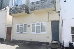 a white house with a black door and windows at Briar Cottage in Looe