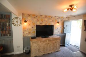 a living room with a flat screen tv on a wall at Briar Cottage in Looe
