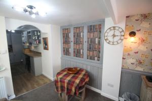 una stanza con tavolo e orologio su una parete di Briar Cottage a Looe 1 altra foto