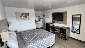 um pequeno quarto de hotel com uma cama e uma televisão em Country Inn Banning em Banning