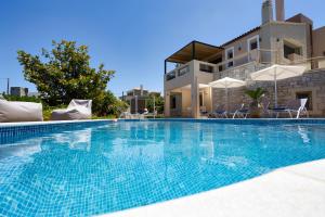 a large swimming pool in front of a house at Palladio Luxury Villa in Roussospítion