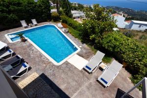 an overhead view of a swimming pool with lounge chairs at Palladio Luxury Villa in Roussospítion