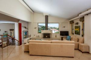 a living room with two couches and a fireplace at Palladio Luxury Villa in Roussospítion