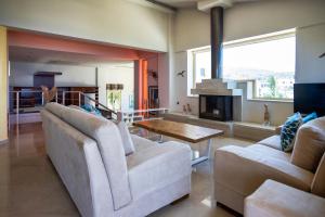 a living room with two couches and a table at Palladio Luxury Villa in Roussospítion