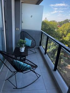 un balcón con 2 sillas y una mesa. en Departamento de Categoria Torre Costanera Norte, Corrientes en Corrientes