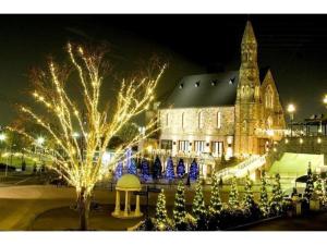 un gran edificio con luces de Navidad delante de él en Hotel Sunlife Garden - Vacation STAY 55411v, en Hiratsuka