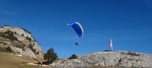 a person flying a parachute over a mountain at Chalet Horn by Apartment Managers in Kitzbühel