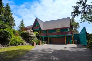 una casa grande con un garaje delante en Enchanting Bavarian Cabin Retreat Pet-Friendly, en Poulsbo