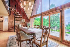 uma sala de jantar com uma mesa e uma grande janela em Enchanting Bavarian Cabin Retreat Pet-Friendly em Poulsbo