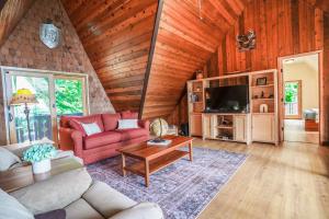 uma sala de estar com um sofá vermelho e uma televisão em Enchanting Bavarian Cabin Retreat Pet-Friendly em Poulsbo