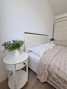 - une chambre avec un lit et une table fleurie dans l'établissement San Casa Apartment, à Sebeş