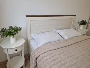 a bedroom with a bed and a table with flowers on it at San Casa Apartment in Sebeş