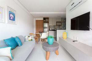 a living room with a couch and a table at CoHost Flat BeachClass EcoLife 104G in Porto De Galinhas