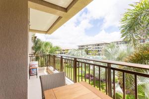 a balcony with a table and chairs and palm trees at CoHost Flat BeachClass EcoLife 104G in Porto De Galinhas