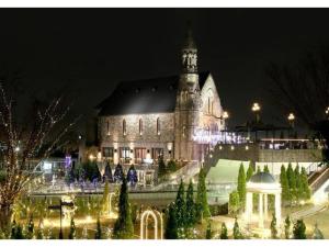 Un gran edificio con una torre de reloj por la noche. en Hotel Sunlife Garden - Vacation STAY 55396v, en Hiratsuka