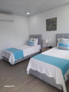 two beds sitting in a room with at Hotel Mar de Corales By CAJASAI in San Andrés