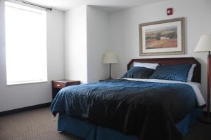 a bedroom with a bed with blue sheets and a window at Beach Fantasy Apartment Suites in Old Orchard Beach