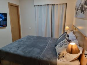 ein Schlafzimmer mit einem Bett mit einer Lampe und einem Fenster in der Unterkunft Apartamento Vista Maravilhosa - Próximo da Paulista in São Paulo