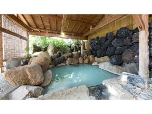 una gran piscina de agua con rocas alrededor en Tsukioka Onsen Furinya - Vacation STAY 55972v en Shibata