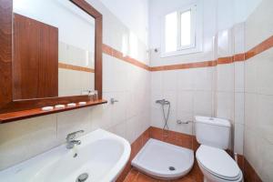 a bathroom with a toilet and a sink and a mirror at Chrissafis Hotel in Panagia