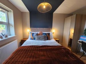 1 dormitorio con 1 cama grande con manta roja en Lynwood House City Center ideal for long stays en Sheffield
