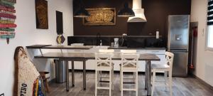 a kitchen with a table and chairs and a refrigerator at Lovely Home LH à proximité de la plage in Le Havre