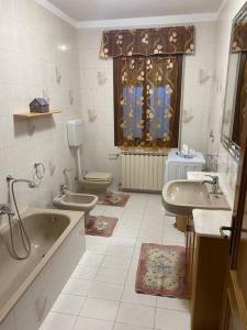 een badkamer met een bad, een toilet en een wastafel bij “Casa Alex” a pochi km dal mare in Scardovari