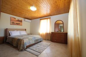 a bedroom with a bed and a wooden ceiling at Anemoessa Mesonet in Romanón