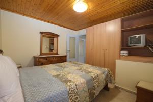 a bedroom with a bed and a tv on a wall at Anemoessa Mesonet in Romanón