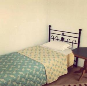 a small bedroom with a bed and a table at Sirinevler Apart IMROS in Gokceada Town