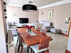 een eetkamer en een woonkamer met een houten tafel en stoelen bij Apartment 13 - Your Perfect Stay in Durres City in Durrës