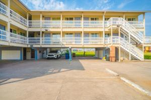 a large yellow building with white balconies and a parking lot at Budget Inn By OYO Corpus Christi Beach in Corpus Christi