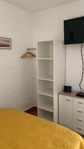 1 dormitorio con 1 cama y TV en la pared en Cassetta 92 Marie-Pierre, en Lumio
