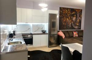 a kitchen with a sink and a couch in a room at S.E.V. Sunset Homes in Vlorë