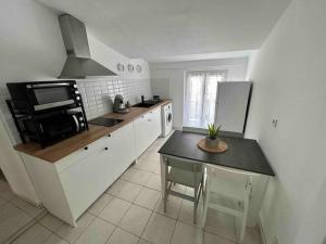 a kitchen with a small table and a microwave at F2 Cosy Centre Ville in Ajaccio