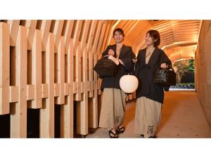 two women are standing next to a wall at URAKUSATSU TOU - Vacation STAY 75063v in Kusatsu