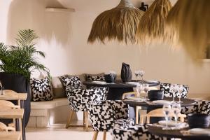 a room with tables and chairs and a couch at Sharm Hotel Mykonos in Mýkonos City