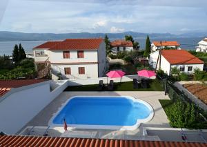 a villa with a swimming pool and a house at Apartments Mihovilovic - 50 m from beach in Slatine