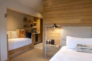 a bedroom with two beds and wooden walls at Inn at the Carlin in Breckenridge
