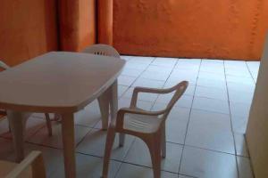 d'une table et de chaises blanches ainsi que de carrelage blanc. dans l'établissement Chalé em Guaramiranga, à Guaramiranga