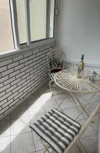 Zimmer mit einem Stuhl, einem Tisch und einer Flasche Wein in der Unterkunft Karla in Split