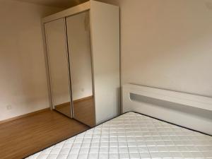 um quarto com um armário no canto de um quarto em Appartement jardin 4 couchages proche aéroport Groupama stadium eurexpo em Saint-Bonnet-de-Mure