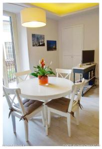 トリノにあるSanta Chiara Apartmentのデスク付きの客室で、白いテーブルと椅子が備わります。