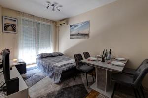1 dormitorio con 1 cama y 1 mesa con sillas en PORTOFINO, with private PARKING, en Novi Sad