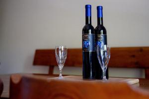 two bottles of wine sitting on a table with glasses at Elegant House in a Beautiful Village in Cerklje ob Krki