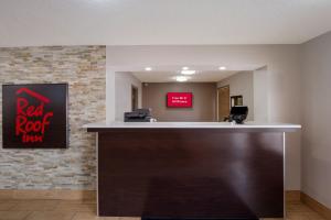 a hotel reception desk with a red rock inn sign at Red Roof Inn Columbia, SC Airport in Columbia