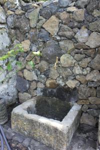 a stone wall with a fountain in front of it at Quinta das Rosas Villas in Ribeira Grande