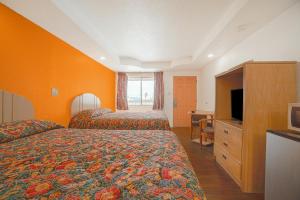 Habitación de hotel con 2 camas y TV en Budget Inn By OYO Corpus Christi Beach, en Corpus Christi