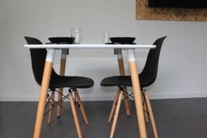 a white table with four black chairs around it at Quinta das Rosas Villas in Ribeira Grande